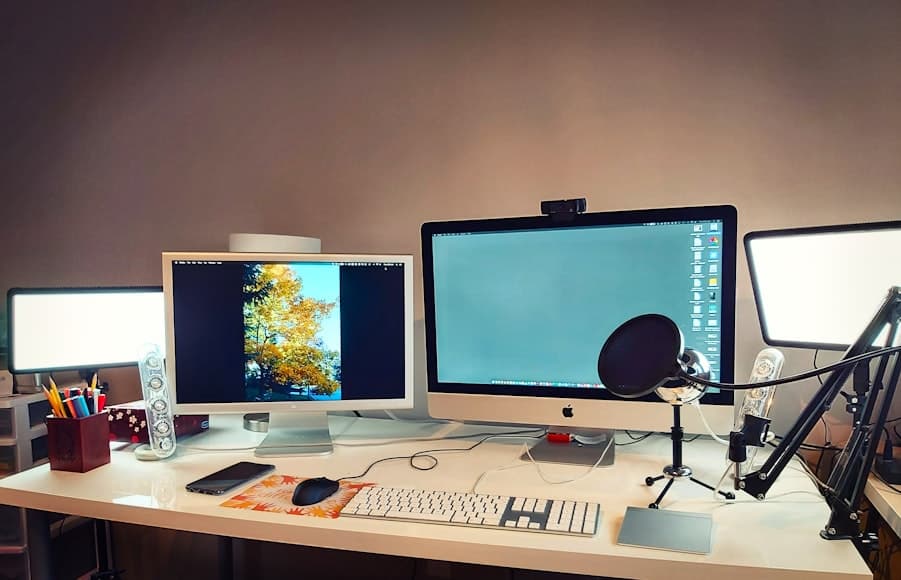 A home office desk with accessories, cables, and work items arranged in a lived-in workspace.