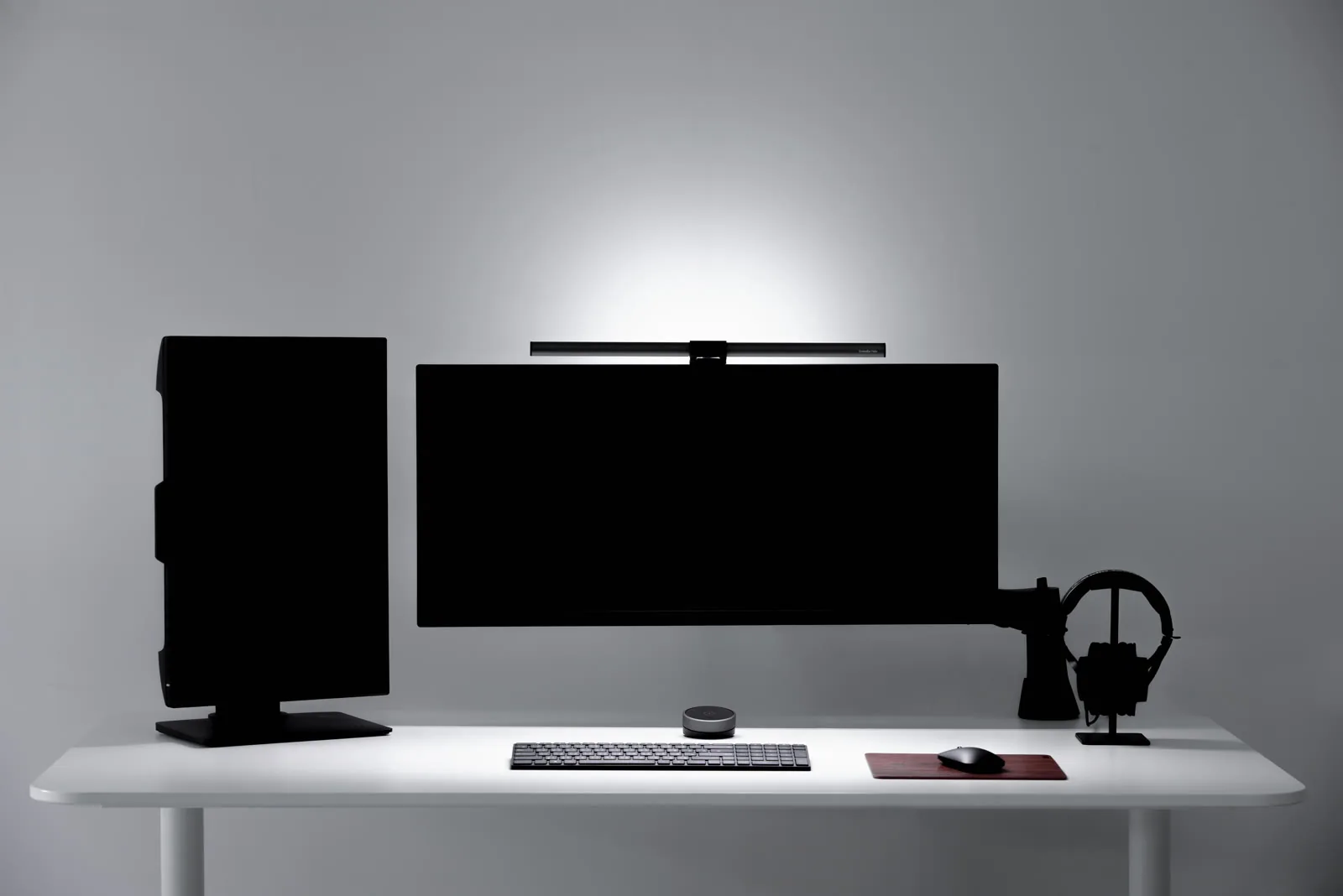 A warm home office desk lit by a monitor light bar in an official BenQ image.