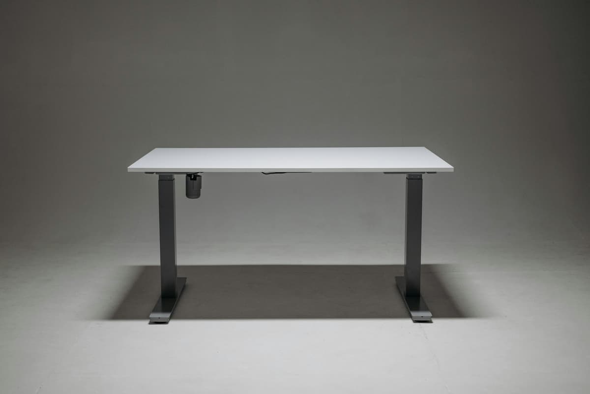 A minimalist white standing desk against a neutral gray backdrop.