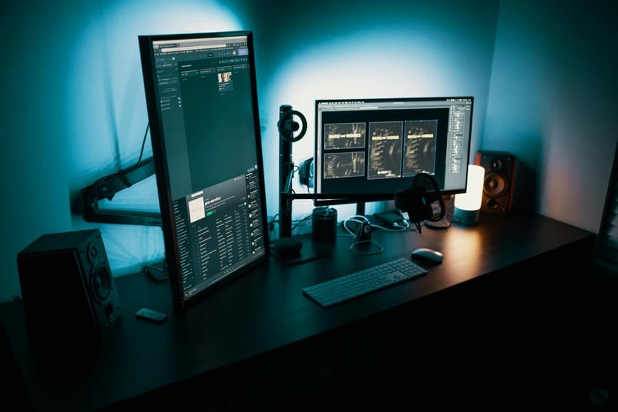 A desk setup with a monitor, chair, and clean work surface in a bright room.