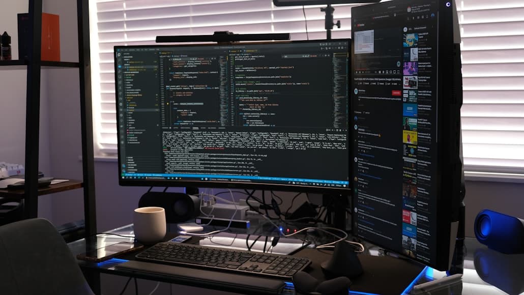 A work desk setup with multiple monitors and accessories arranged in a modern workspace.