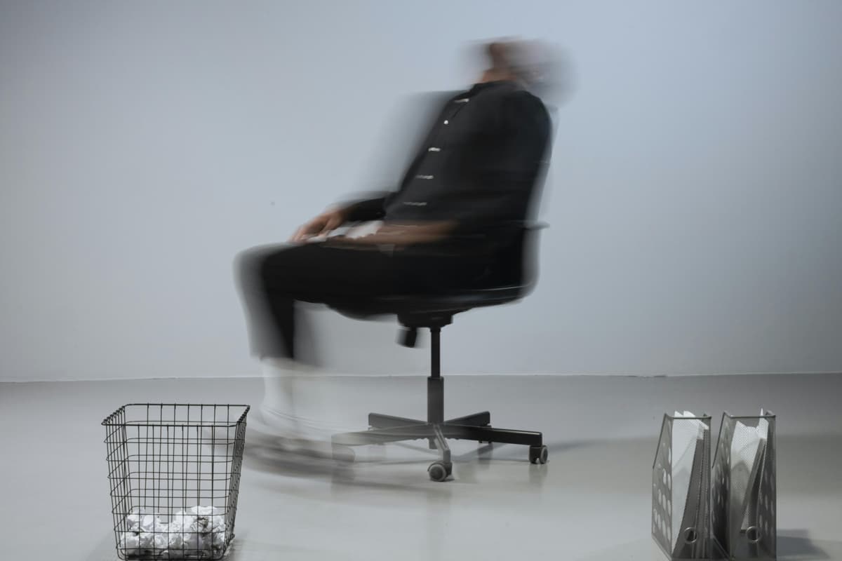 An ergonomic chair beside a modern desk setup in warm lighting.