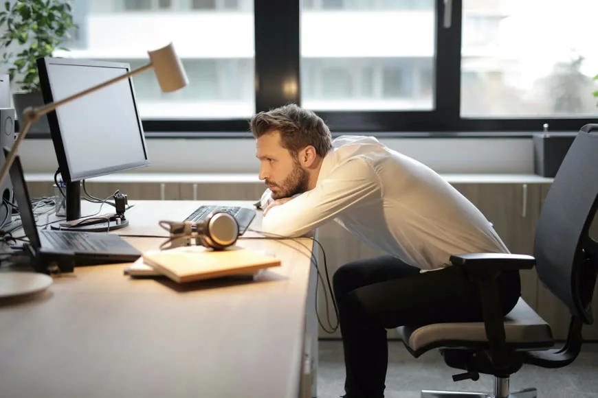 A modern office chair at a workstation in a bright room.