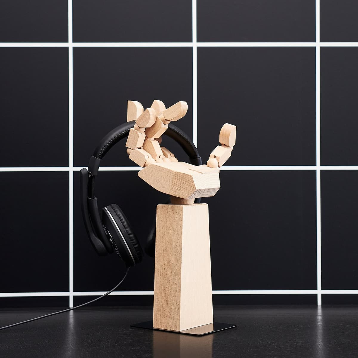 The IKEA LÅNESPELARE accessories stand holding a pair of black headphones.