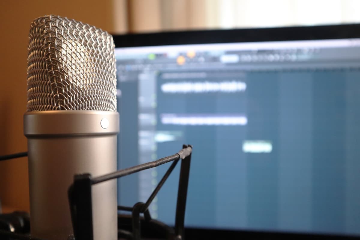 A compact USB microphone on a desk in a calm workspace.