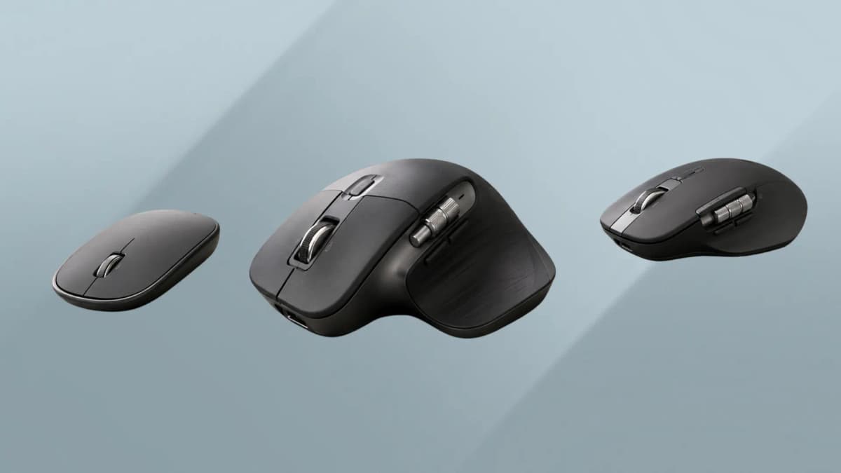 Three wireless productivity mice arranged on a dark desk.