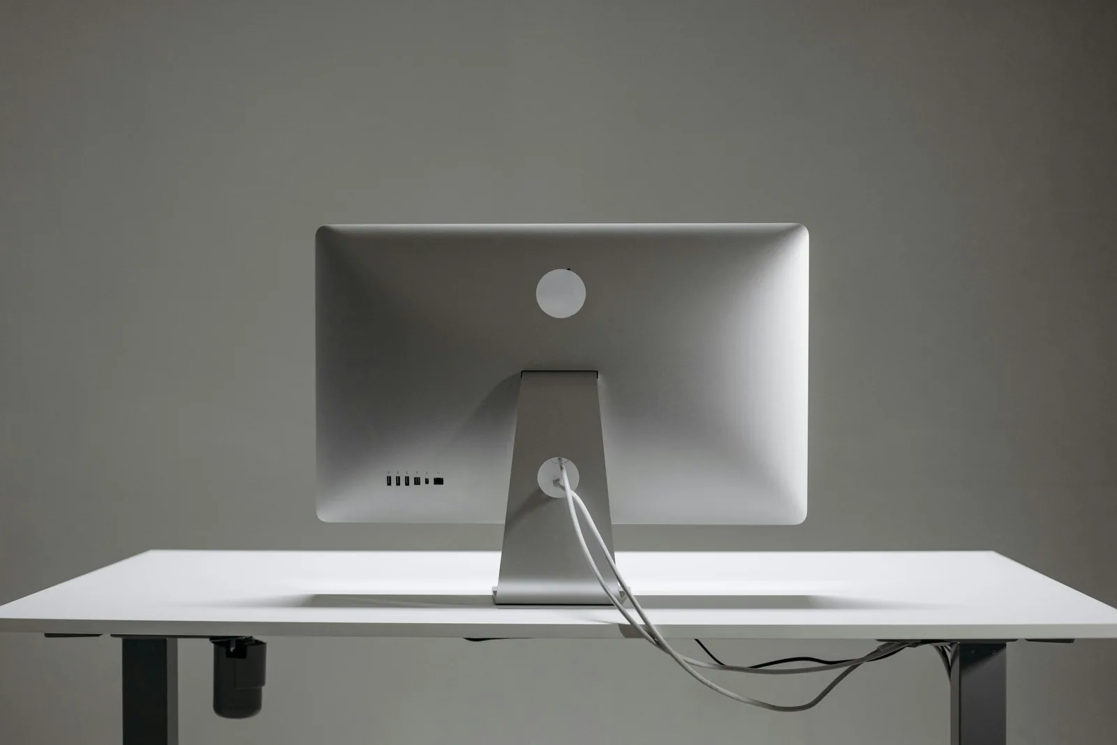 A clean desk setup with cables hidden neatly under the desk and along the wall.