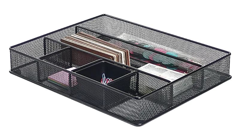 A black mesh drawer organizer tray with divided compartments holding notebooks, paper clips, and small office supplies.