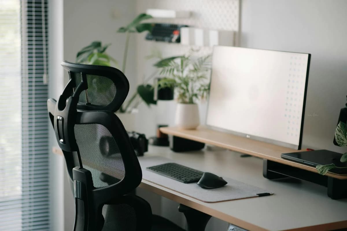 A calm home office with an ergonomic chair, desk, and soft natural light.