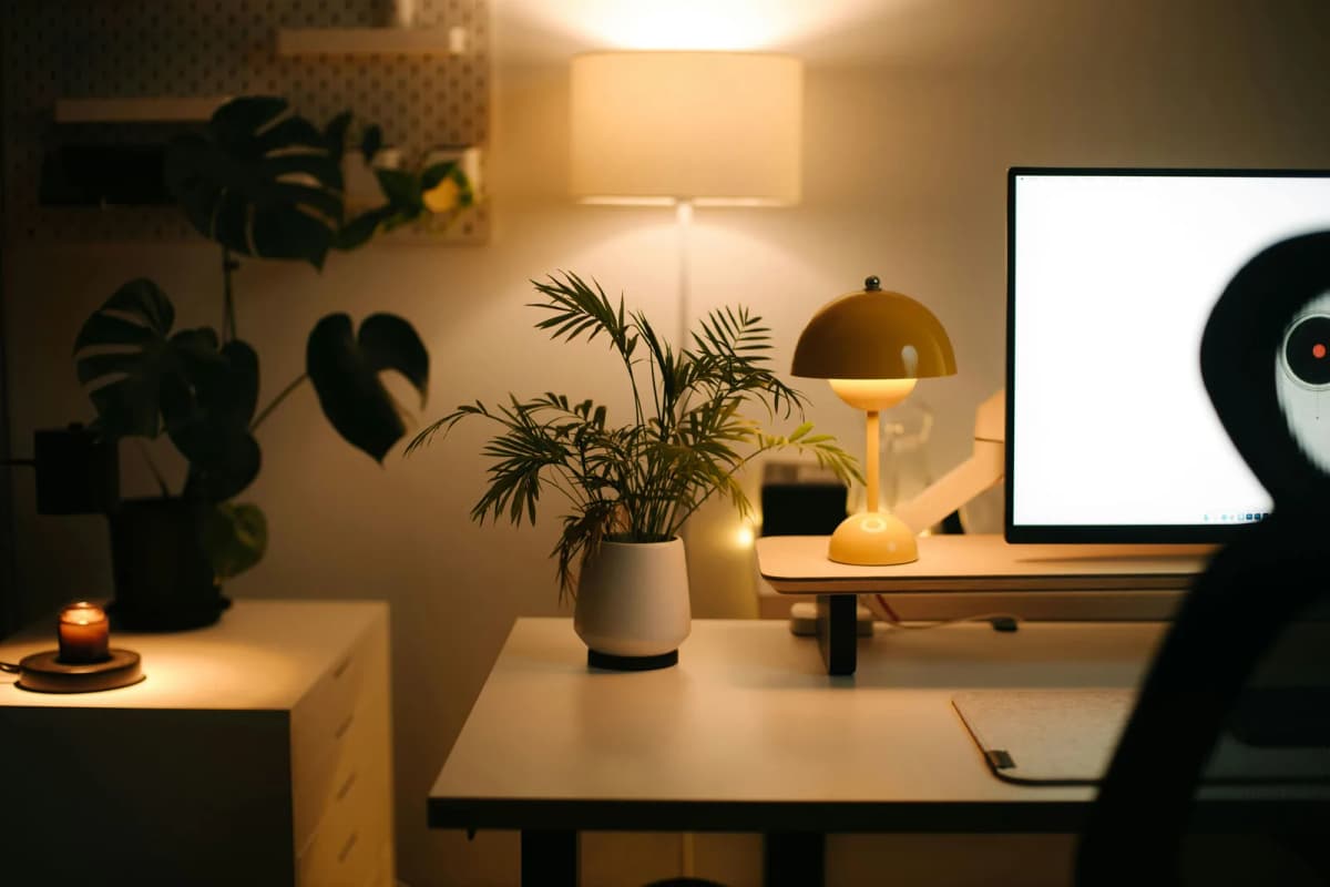 A compact home office desk placed neatly by a bright apartment window.