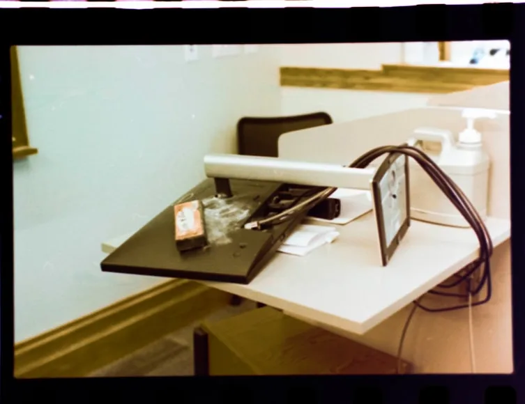 A monitor support arm and base taking up space on a small desk.