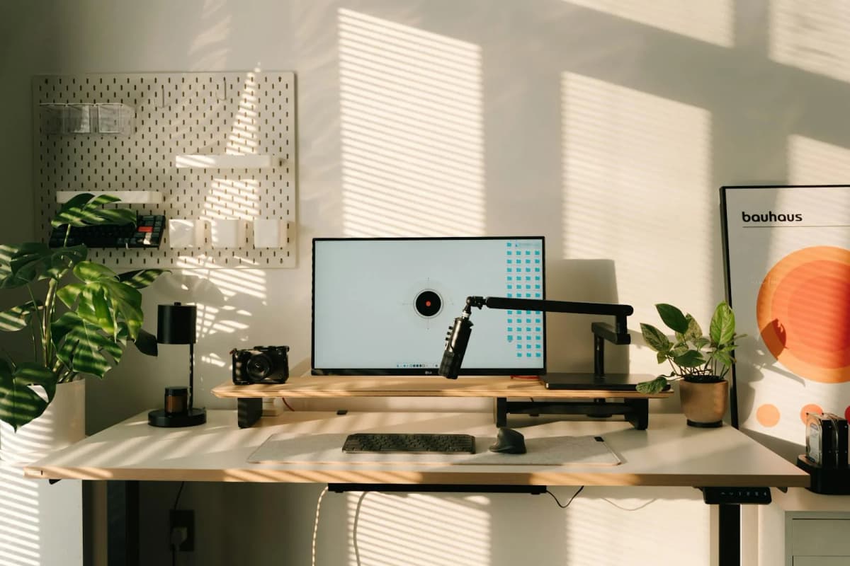 A tidy desk with a raised monitor and organized accessories.