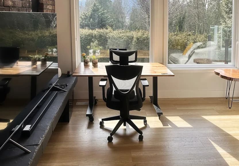 A compact home office corner with a light chair, desk, and calm room styling.