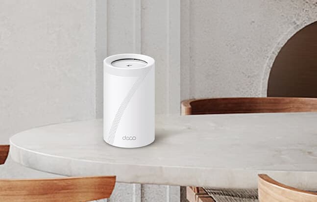 TP-Link Deco BE63 Pro tri-band Wi-Fi 7 mesh system showing three white units on a modern desk setup.