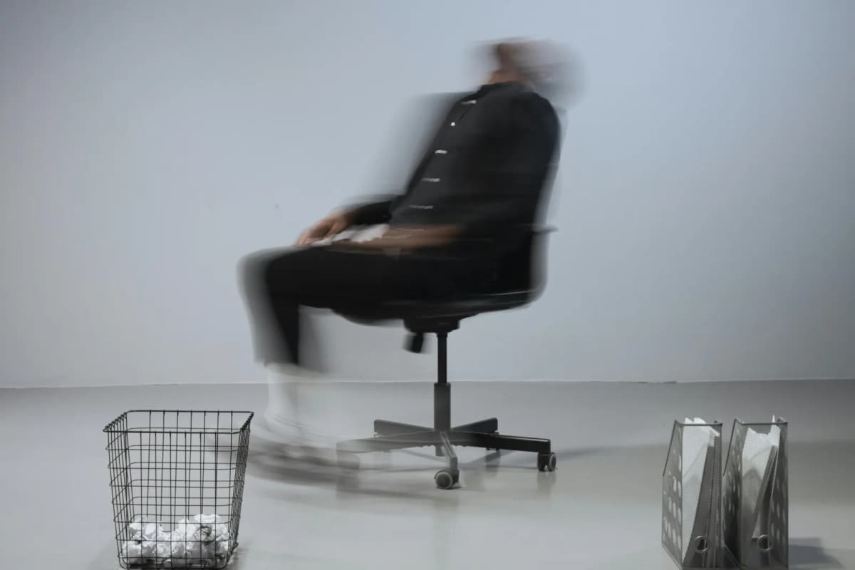 An ergonomic chair beside a modern desk setup in warm lighting.